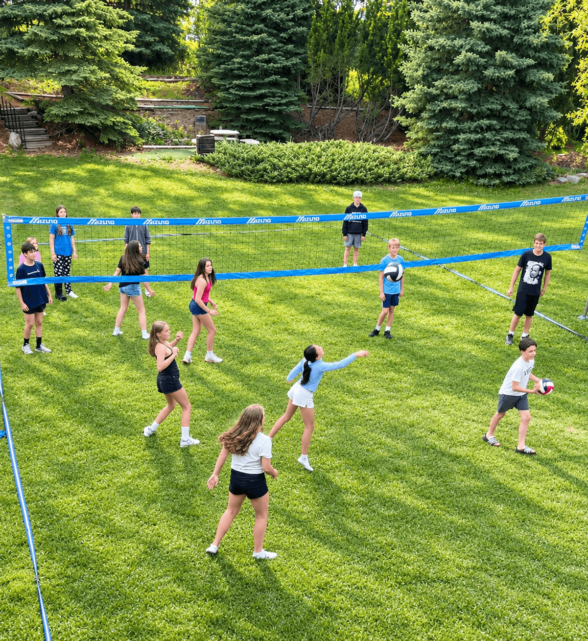 Campers playing volleyball on a grass court